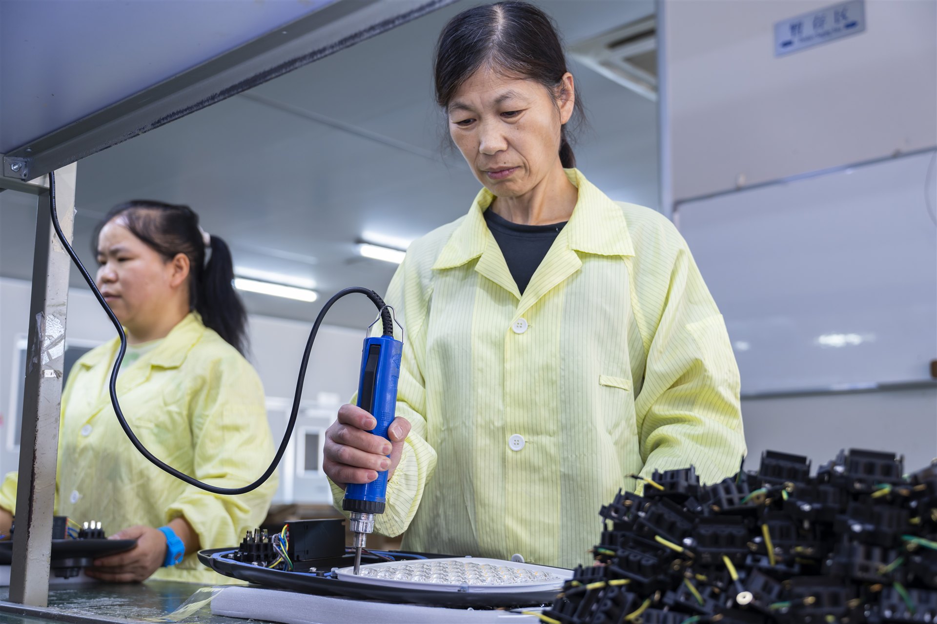 LUXIFIC production worker checking an outdoor street luminaire during assembly