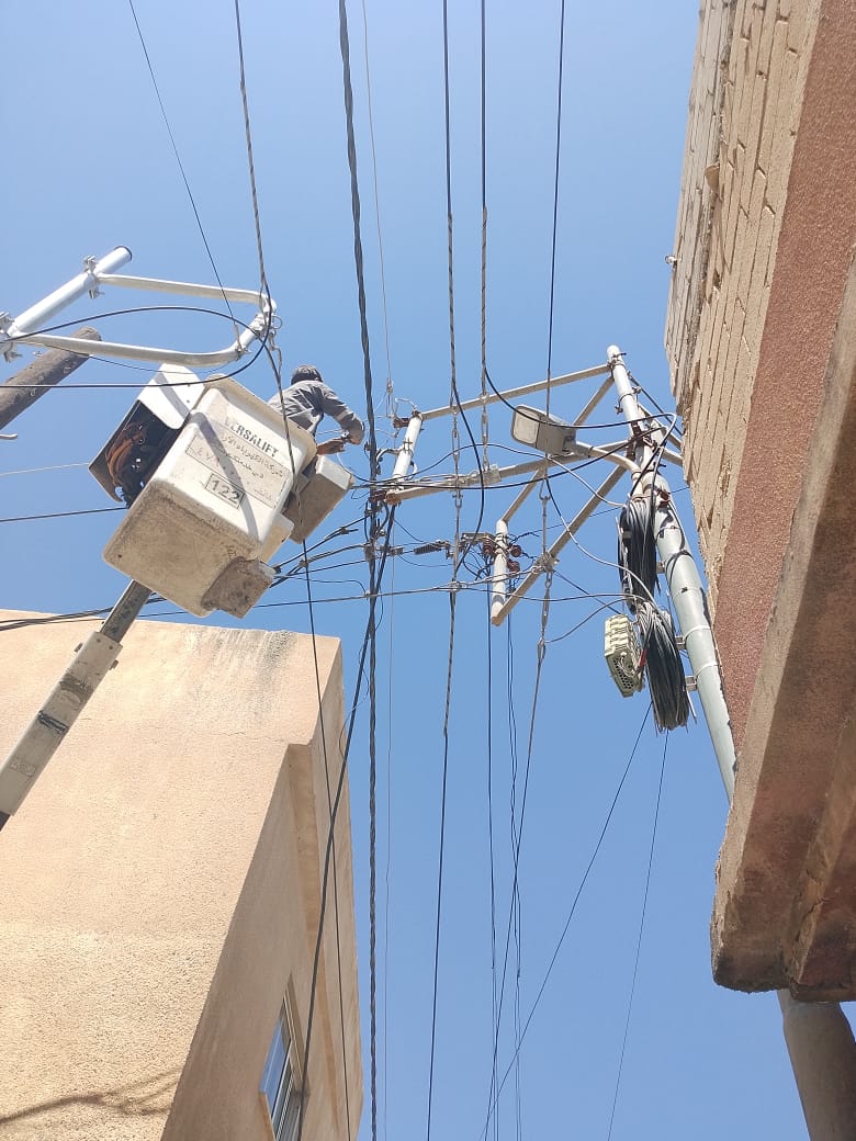 LED street-light installation crew working from an aerial platform in the municipal area, Asia